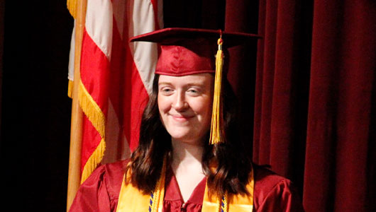 High school student in a maroon cap and gown, symbolizing Greater Denfeld Foundation scholarships and awards