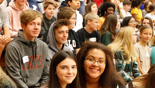 Crowd of high school students sitting on gymnasium risers, illustrating the impact of Greater Denfeld Foundation scholarships on student support and success